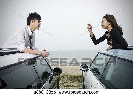 Woman taking a photo of man from a car View Large Photo Image Stock Photography - Woman taking a photo of man from a car . Fotosearch