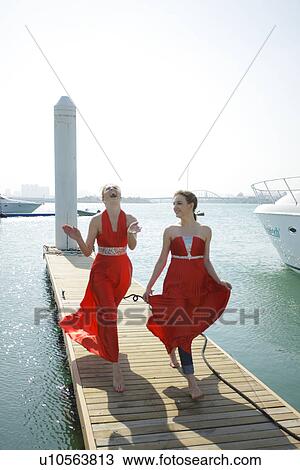 Stock Image - Women walking on a pier . Fotosearch