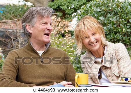 Adult couple having a coffee break in garden View Large Photo Image Stock Image - Adult couple having a coffee break in garden. Fotosearch