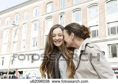 Affectionate mother and teenage daughter on city street View Large Photo Image Stock Photo - Affectionate mother and teenage daughter on city street. Fotosearch