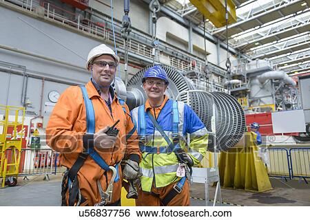Stock Photograph - Banksman and crane operator in turbine hall during power station outage, portrait. Fotosearch