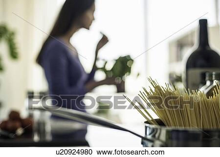 Blurred image of young woman preparing food in kitchen View Large Photo Image Stock Image - Blurred image of young woman preparing food in kitchen. Fotosearch