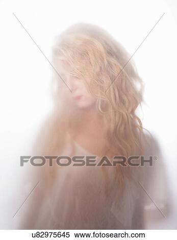 Blurred shot of young woman gazing down behind frosted glass View Large Photo Image Stock Photography - Blurred shot of young woman gazing down behind frosted glass. Fotosearch