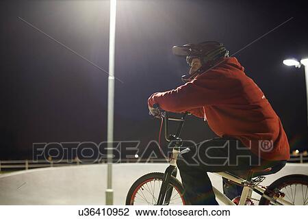Stock Image - BMX-cyclist riding at night time. Fotosearch