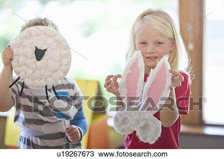 Boy and girl holding up sheep and rabbit creations at nursery school View Large Photo Image Stock Image - Boy and girl holding up sheep and rabbit creations at nursery school. Fotosearch