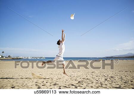 Boy jumping and throwing hat mid air on beach View Large Photo Image Stock Image - Boy jumping and throwing hat mid air on beach. Fotosearch