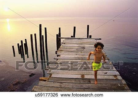 Boy running on jetty in Maldives View Large Photo Image Stock Photograph - Boy running on jetty in Maldives. Fotosearch