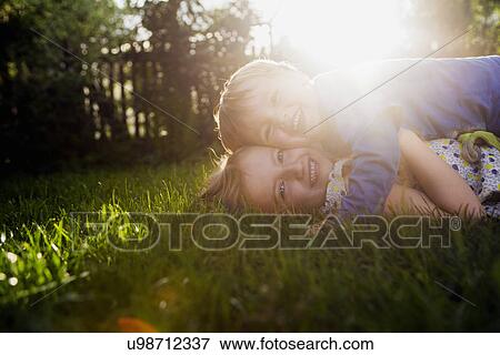 Brother and sister lying on grass, hugging View Large Photo Image Stock Photo - Brother and sister lying on grass, hugging. Fotosearch