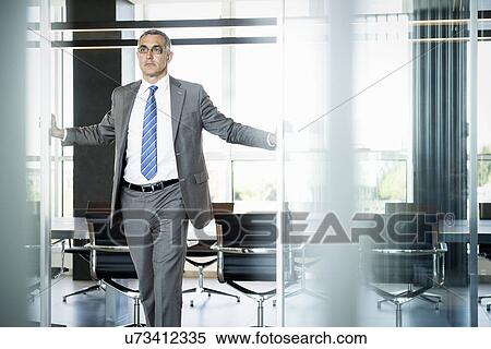 Stock Photography - Businessman at entrance of meeting room. Fotosearch