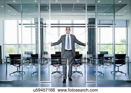 Stock Photograph - Businessman at entrance to meeting room. Fotosearch