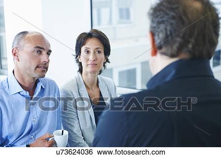 Businesspeople chatting in office View Large Photo Image Stock Photograph - Businesspeople chatting in office. Fotosearch