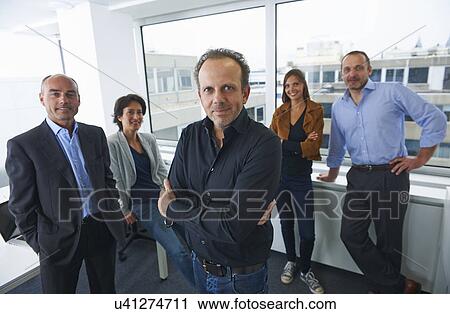 Stock Image - Businesspeople posing for group portrait in office. Fotosearch