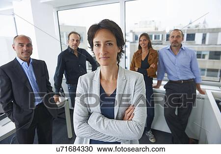 Stock Image - Businesspeople posing for group portrait in office. Fotosearch