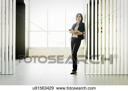 Businesswoman leaning against glass wall View Large Photo Image Stock Photo - Businesswoman leaning against glass wall. Fotosearch