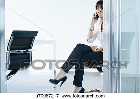 Businesswoman on smartphone in meeting room View Large Photo Image Stock Photo - Businesswoman on smartphone in meeting room. Fotosearch