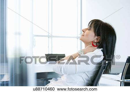 Stock Image - Businesswoman resting in meeting room. Fotosearch
