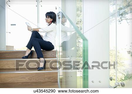 Businesswoman using digital tablet on steps View Large Photo Image Stock Image - Businesswoman using digital tablet on steps. Fotosearch