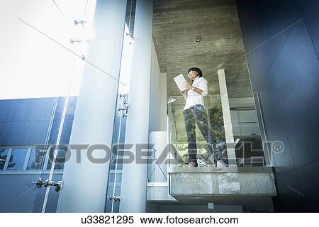 Businesswoman using digital tablet on balcony View Large Photo Image Stock Photography - Businesswoman using digital tablet on balcony. Fotosearch
