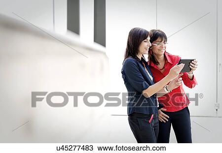 Businesswomen using digital tablet View Large Photo Image Stock Image - Businesswomen using digital tablet. Fotosearch