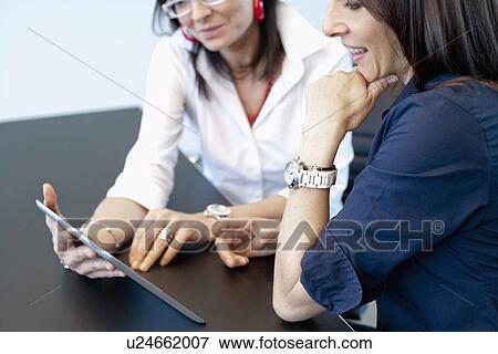 Businesswomen using digital tablet View Large Photo Image Stock Photo - Businesswomen using digital tablet. Fotosearch