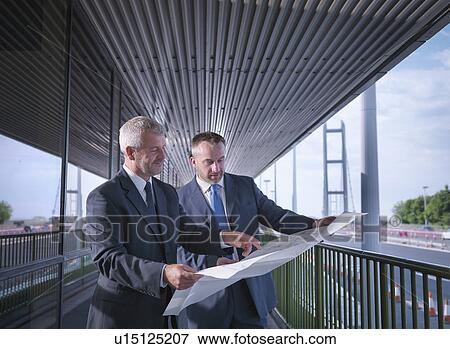 Stock Photo - Civil engineering architects inspecting plans of suspension bridge. The Humber Bridge, UK, built in 1981 was the world's largest single-span suspension bridge. Fotosearch