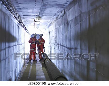 Stock Photography - Civil engineers in discussion in tunnel of suspension bridge. The Humber Bridge, UK, built in 1981 was the world's largest single-span suspension bridge. Fotosearch