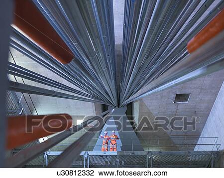 Stock Image - Civil engineers inspecting cable anchorage in suspension bridge, low angle view. The Humber Bridge, UK, built in 1981 was the world's largest single-span suspension bridge. Fotosearch