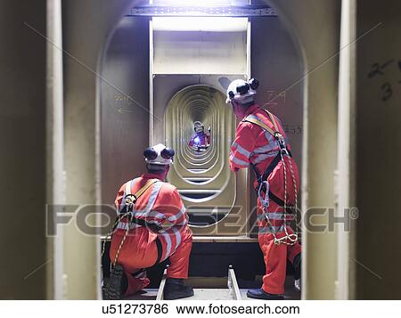 Stock Photograph - Civil engineers inspecting structure under carriageway of suspension bridge. The Humber Bridge, UK, built in 1981 was the world's largest single-span suspension bridge. Fotosearch