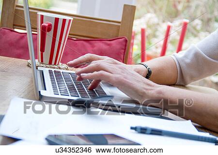 Close up of mature female hands using laptop in kitchen View Large Photo Image Stock Photograph - Close up of mature female hands using laptop in kitchen. Fotosearch