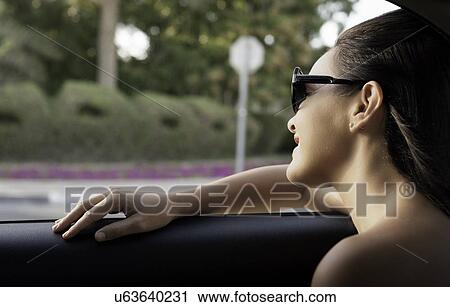 Close up of young woman looking out of taxi window View Large Photo Image Stock Image - Close up of young woman looking out of taxi window. Fotosearch