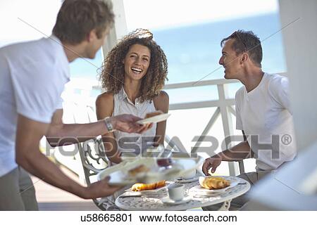 Couple having breakfast on beach house balcony View Large Photo Image Stock Image - Couple having breakfast on beach house balcony. Fotosearch
