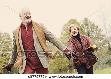 Stock Photo - Couple holding hands in garden. Fotosearch