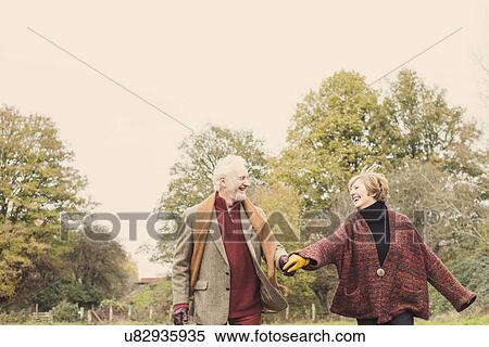 Couple holding hands in garden View Large Photo Image Stock Photography - Couple holding hands in garden. Fotosearch