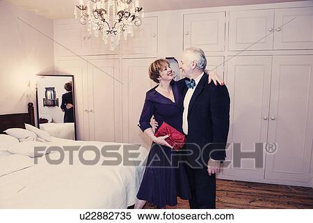 Stock Photography - Couple in bedroom, mature woman with arm around senior man. Fotosearch