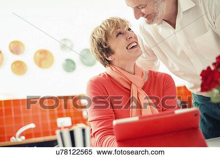 Couple in kitchen, woman with digital tablet View Large Photo Image Stock Photography - Couple in kitchen, woman with digital tablet. Fotosearch