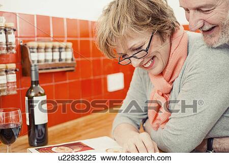 Couple reading cook book in kitchen View Large Photo Image Stock Photography - Couple reading cook book in kitchen. Fotosearch