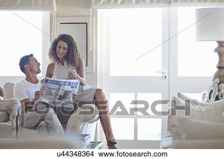 Picture - Couple reading newspaper in sitting room. Fotosearch