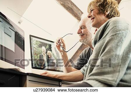 Picture - Couple using computer at home. Fotosearch