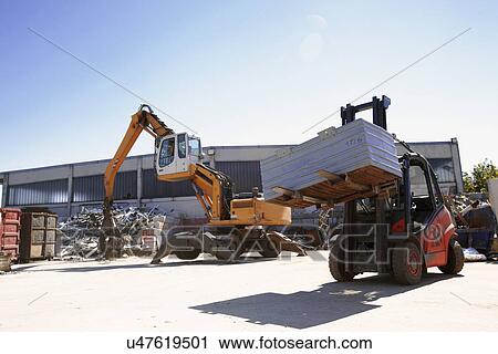 Crane grab and fork lift truck sorting and moving metals in scrap yard View Large Photo Image Stock Image - Crane grab and fork lift truck sorting and moving metals in scrap yard. Fotosearch