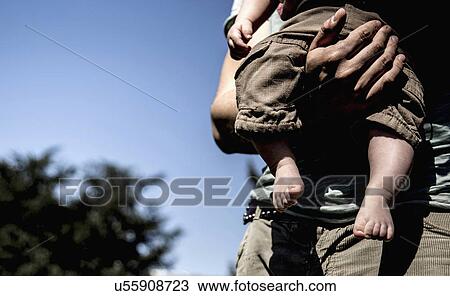 Cropped close up of young man carrying baby son View Large Photo Image Stock Image - Cropped close up of young man carrying baby son. Fotosearch