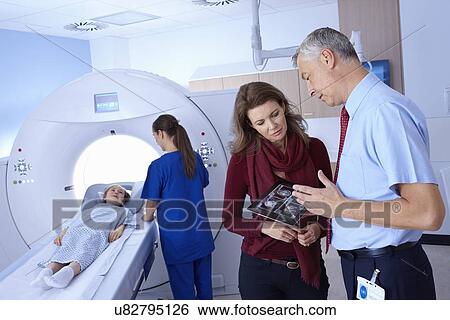 Doctor and mother looking at scan, girl going into CT scanner View Large Photo Image Stock Photograph - Doctor and mother looking at scan, girl going into CT scanner. Fotosearch