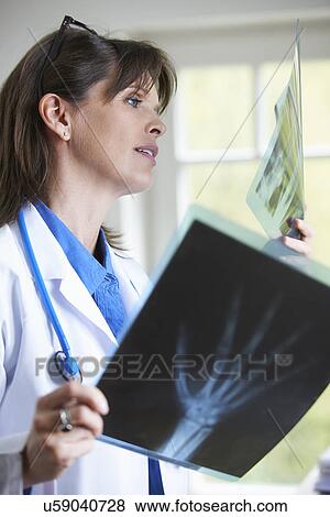 Stock Photo - Doctor looking at xray image of hand. Fotosearch