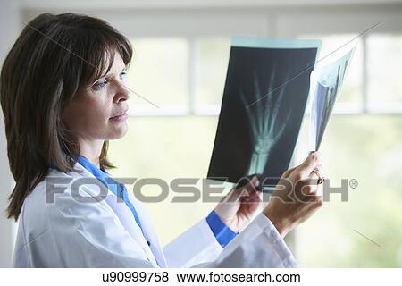 Stock Photo - Doctor looking at xray image of hand. Fotosearch