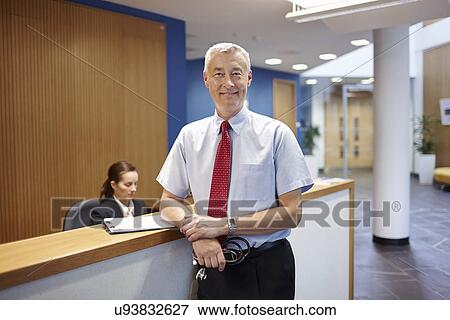 Stock Photo - Doctor standing in hospital waiting room. Fotosearch