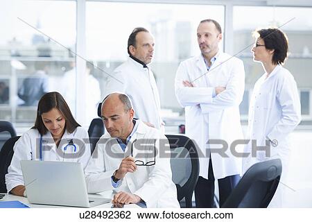 Stock Image - Doctors in brainstorming meeting. Fotosearch