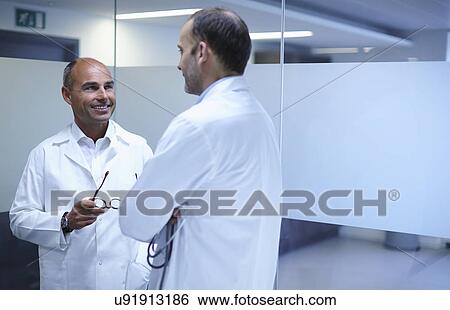 Doctors taking break in office View Large Photo Image Stock Photograph - Doctors taking break in office. Fotosearch