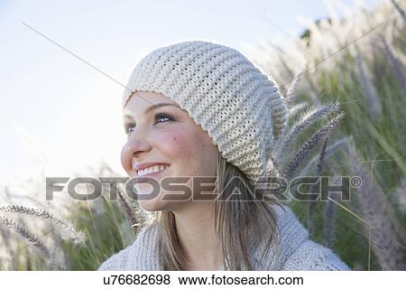 Stock Photo - Dreamy portrait of smiling young woman in long grass. Fotosearch