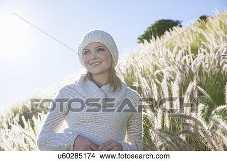 Dreamy portrait of young woman gazing from long grass View Large Photo Image Picture - Dreamy portrait of young woman gazing from long grass. Fotosearch