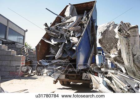 Dump truck emptying aluminium from skip into scrap yard View Large Photo Image Picture - Dump truck emptying aluminium from skip into scrap yard. Fotosearch