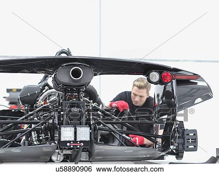 Stock Photograph - Engineer assembling supercar in sports car factory. Fotosearch